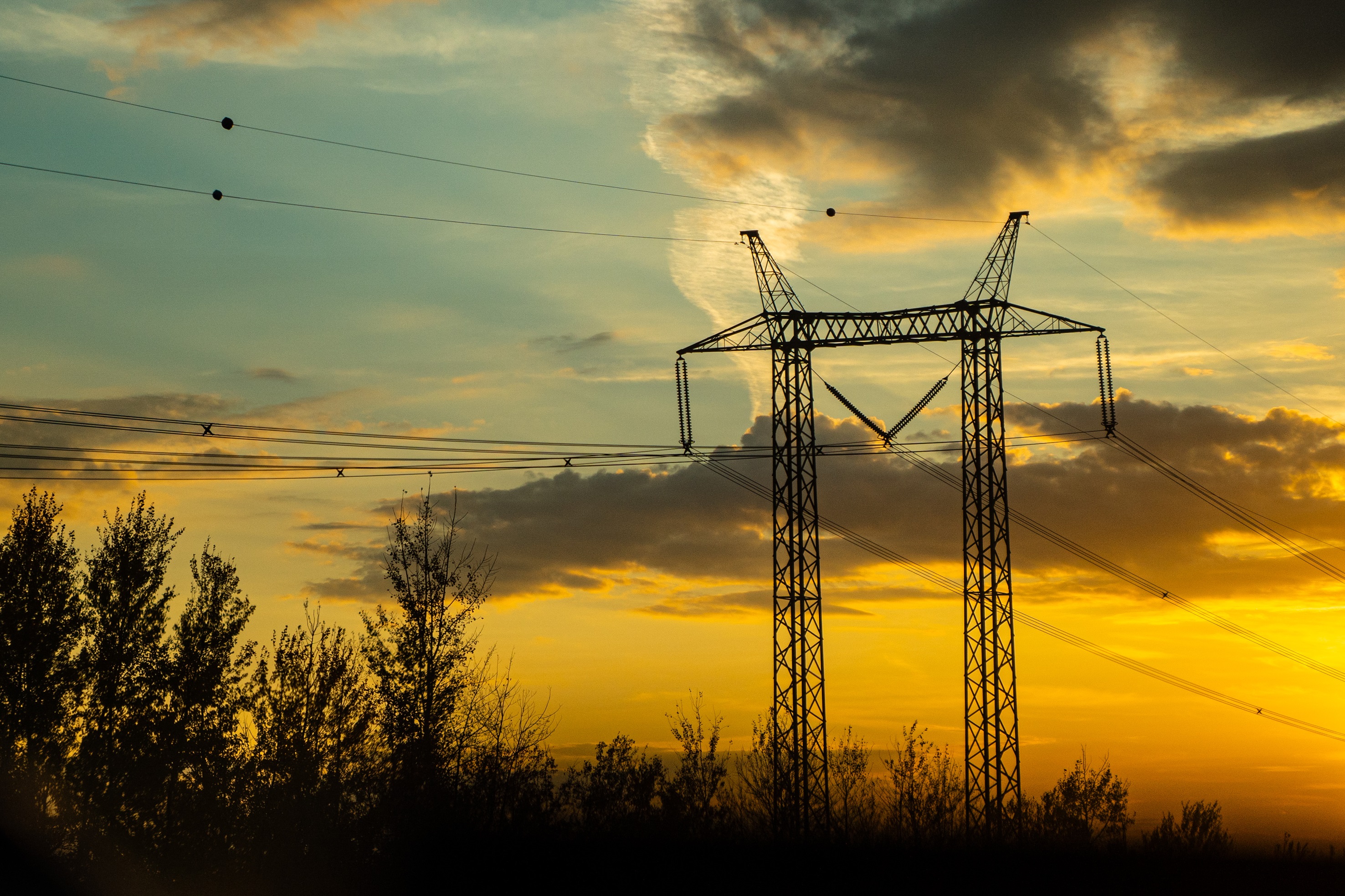 Image of sunset through clouds and an electrical line